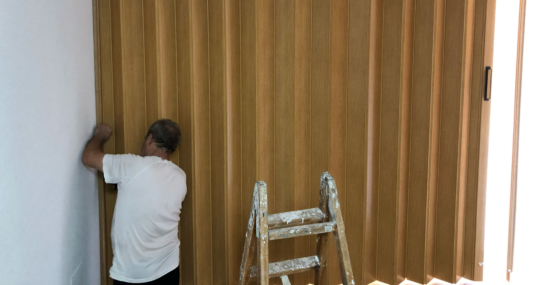 carpintero instalando una puerta plegable de color roble